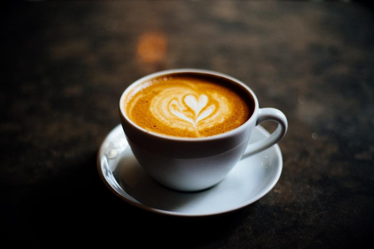 Close-up of a pour-over coffee setup with freshly ground beans and a steaming cup, highlighting the art of brewing
