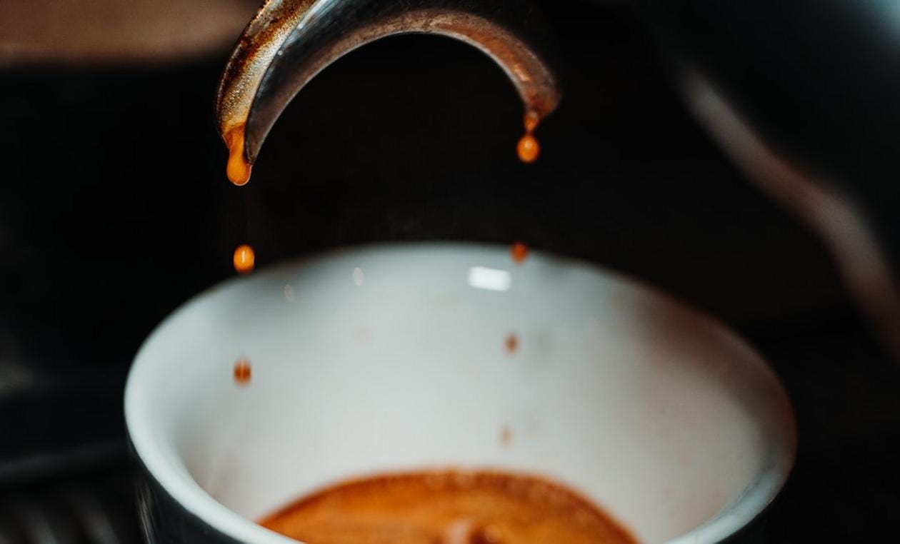 Close-up of brewing coffee with a pour-over setup and freshly ground beans
